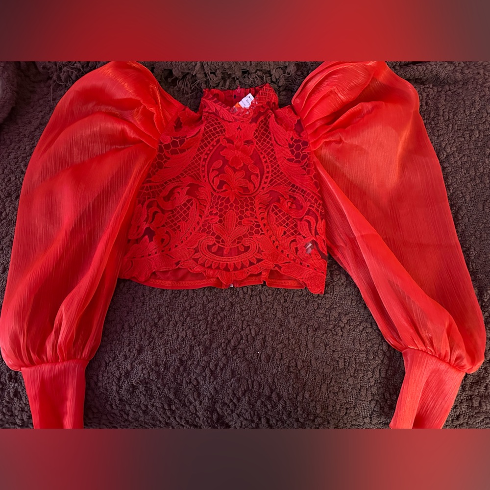 Red Akira crotchet top with puffy long sleeves with tag.